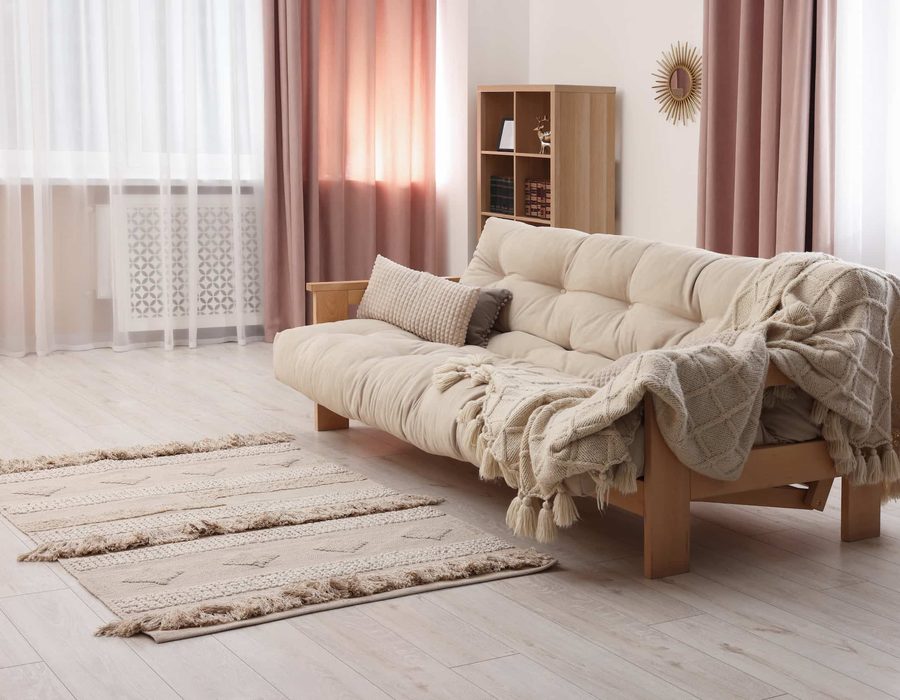 A neutral sofa with a throw blanket