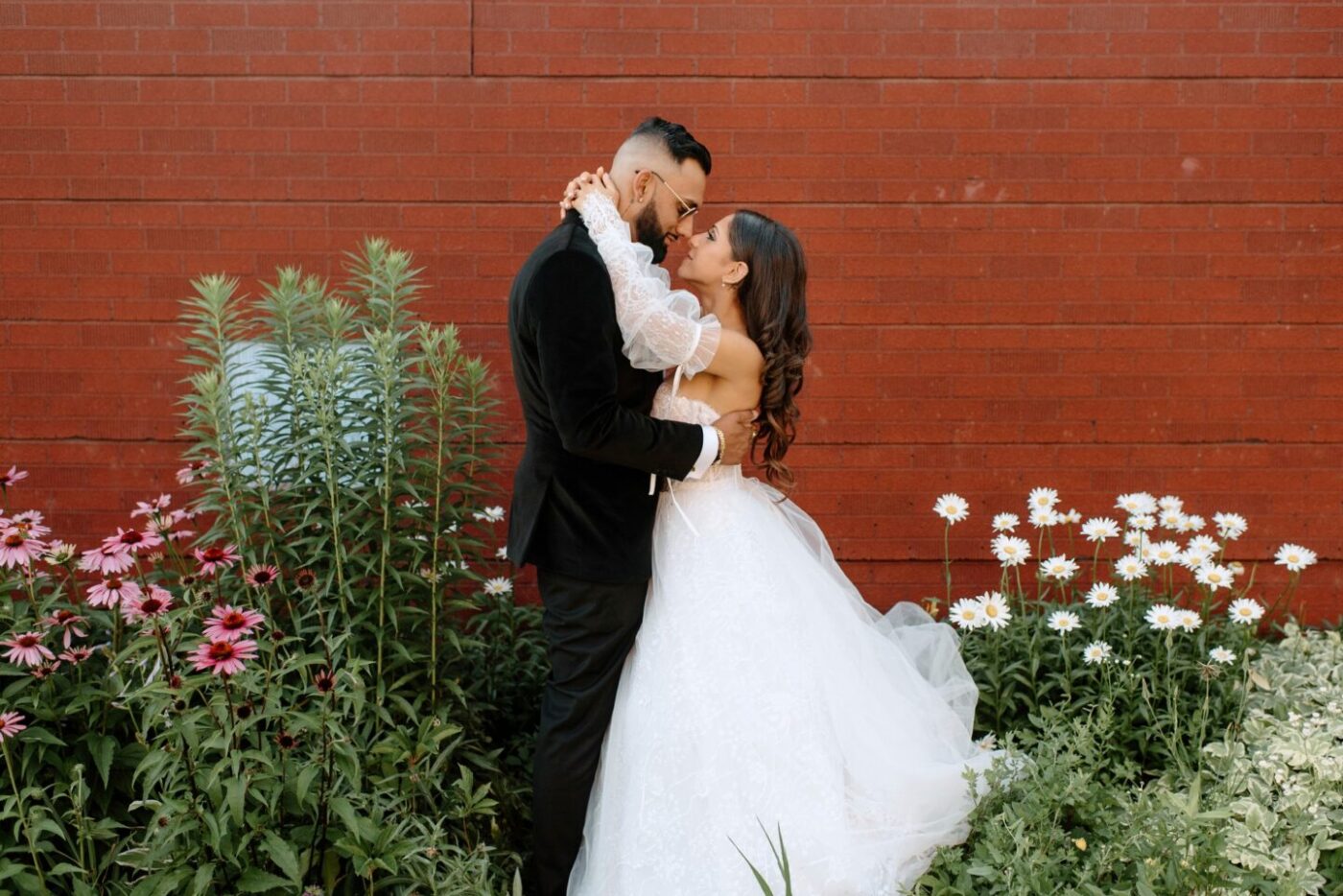 Couple against a brick wall backdrop
