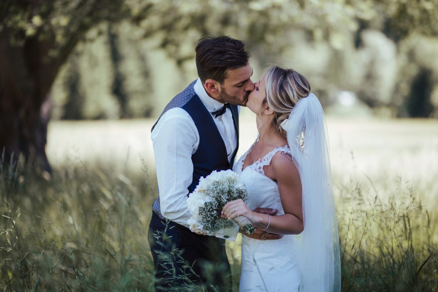 Bride and groom kissing outdoors